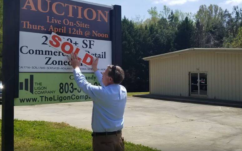 Auctioneer posting sign